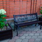 Зона отдыха с лавочкой и цветами во дворе гостевого дома
