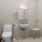 Оборудованная для маломобильных людей ванная, поручни, стул.